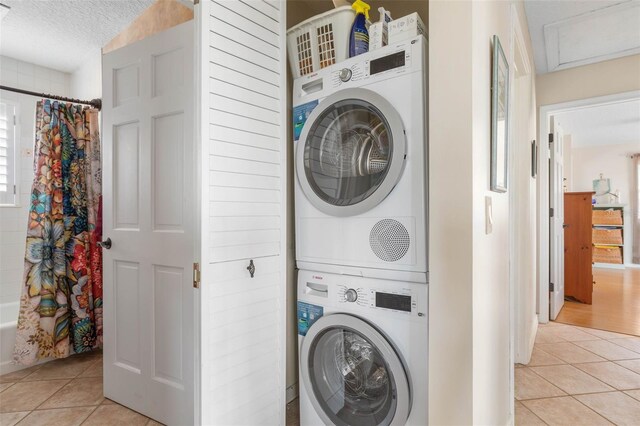 6973 N Oceanshore Blvd, Palm Coast, FL 32137 - washroom featuring stacked washer / drying machine, light tile patterned flooring, and a textured ceiling