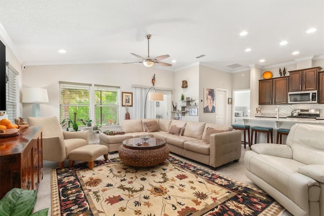 living area with ornamental molding, ceiling fan, recessed lighting, and light tile patterned flooring
