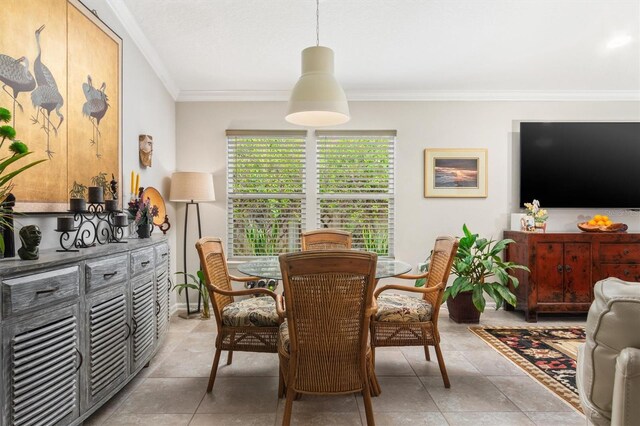dining space featuring crown molding and light tile patterned floors
