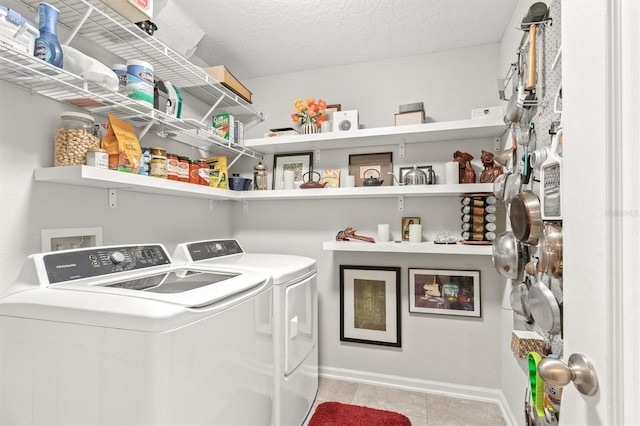 washroom with washer and clothes dryer, tile patterned flooring, baseboards, and a textured ceiling