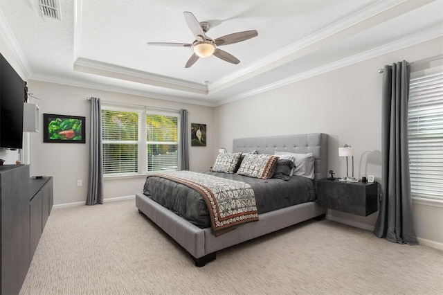 bedroom with a tray ceiling, light colored carpet, ornamental molding, a ceiling fan, and baseboards