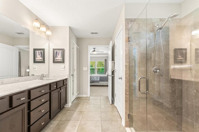 full bath featuring a shower stall, ensuite bath, tile patterned flooring, vanity, and a textured ceiling