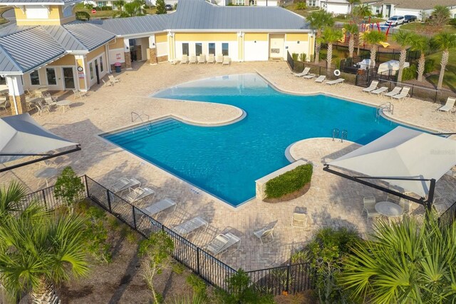 community pool with fence and a patio