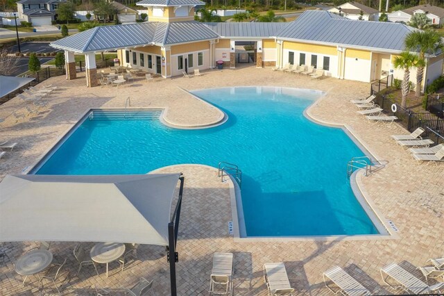 community pool featuring fence and a patio area