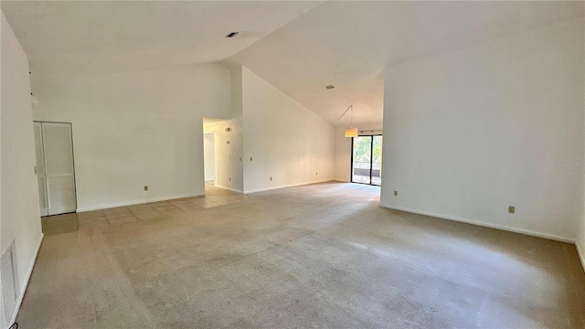 spare room with carpet floors, high vaulted ceiling, and baseboards