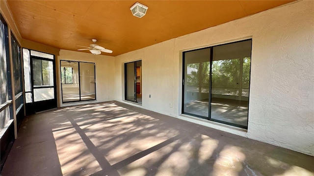 unfurnished sunroom with ceiling fan and plenty of natural light