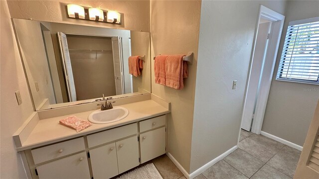 bathroom with tile patterned flooring, vanity, and baseboards