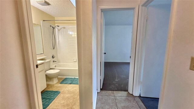 full bath featuring tile patterned flooring, toilet, shower / washtub combination, a textured ceiling, and vanity