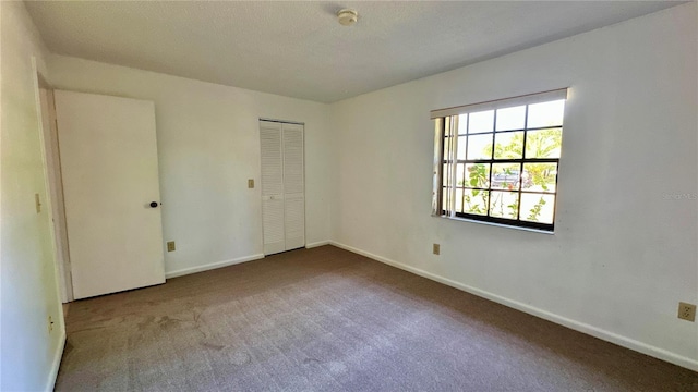 unfurnished bedroom featuring carpet flooring, baseboards, and a closet
