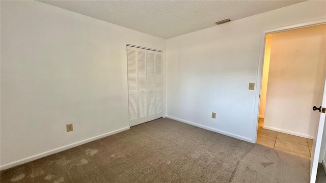 unfurnished bedroom with carpet flooring, baseboards, and a closet