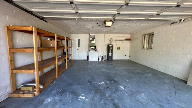 garage with water heater, a garage door opener, and concrete block wall