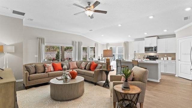 living room featuring light wood-type flooring, ceiling fan, lofted ceiling, and visible vents