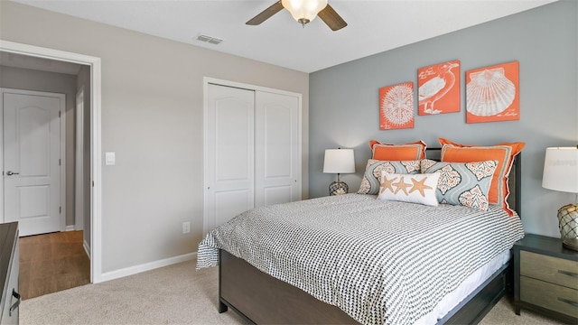 bedroom featuring a closet, carpet, baseboards, ceiling fan, and visible vents