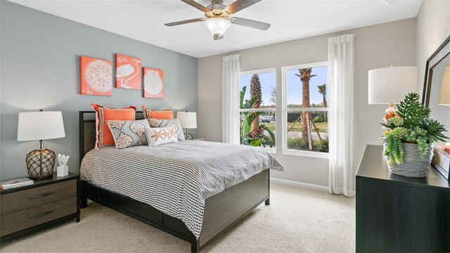 bedroom featuring ceiling fan, light carpet, and baseboards