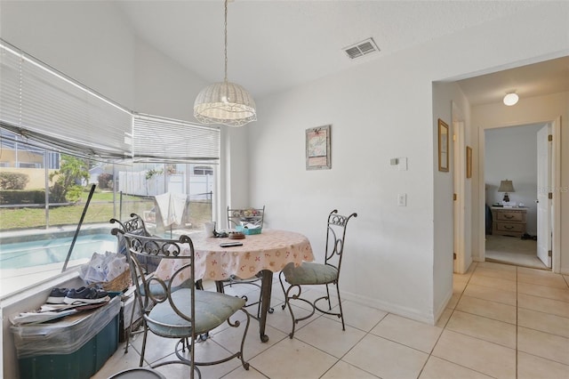 1956 Southern Dunes Blvd, Haines City, FL 33844 - dining space with light tile patterned floors, vaulted ceiling, and baseboards