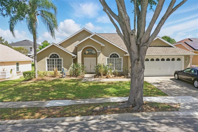 1956 Southern Dunes Blvd, Haines City, FL 33844 - view of front facade featuring an attached garage, driveway, stucco siding, and a front yard