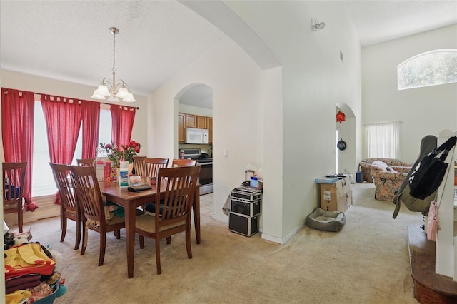 1305 Rebecca Dr, Haines City, FL 33844 - dining area featuring arched walkways, a chandelier, light carpet, and a high ceiling