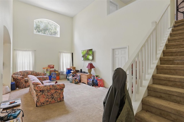 1305 Rebecca Dr, Haines City, FL 33844 - carpeted living room with a high ceiling, stairs, and arched walkways