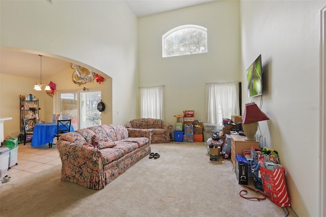 1305 Rebecca Dr, Haines City, FL 33844 - carpeted living room with arched walkways, a towering ceiling, healthy amount of natural light, tile patterned floors, and a chandelier