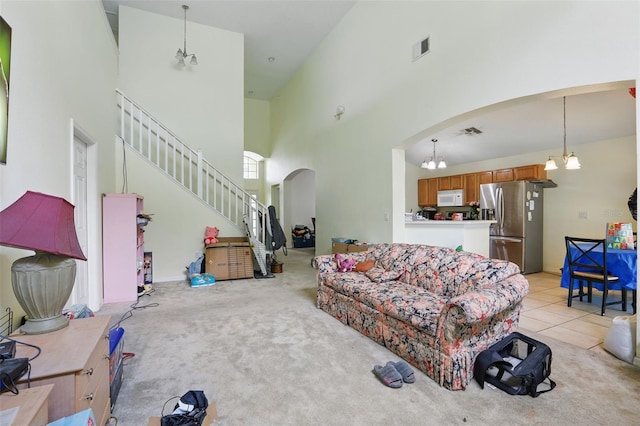 1305 Rebecca Dr, Haines City, FL 33844 - living room with arched walkways, a towering ceiling, a chandelier, light colored carpet, and stairs