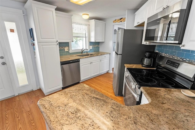 151 Lookout Dr, Flagler Beach, FL 32136 - kitchen featuring stainless steel appliances, a sink, light wood-type flooring, and backsplash