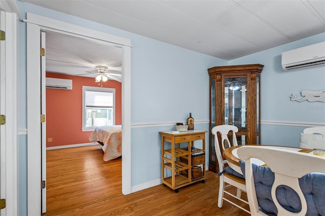 151 Lookout Dr, Flagler Beach, FL 32136 - dining space featuring a wall mounted AC, wood finished floors, a ceiling fan, and baseboards