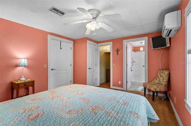 151 Lookout Dr, Flagler Beach, FL 32136 - bedroom featuring wood finished floors, an AC wall unit, baseboards, and a ceiling fan