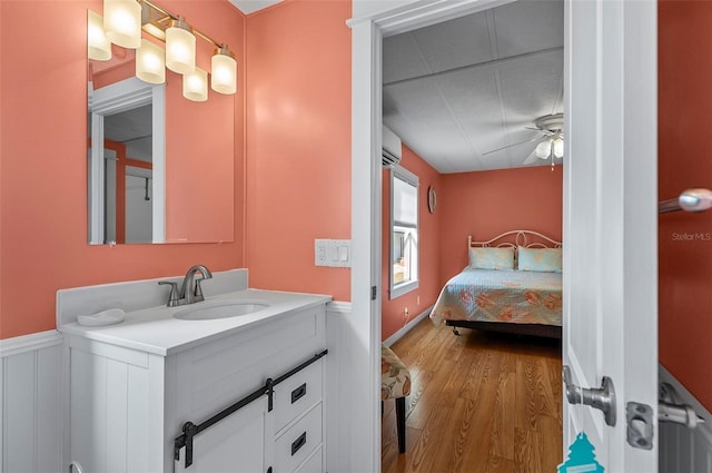 151 Lookout Dr, Flagler Beach, FL 32136 - bathroom featuring wood finished floors, wainscoting, ceiling fan, vanity, and ensuite bath