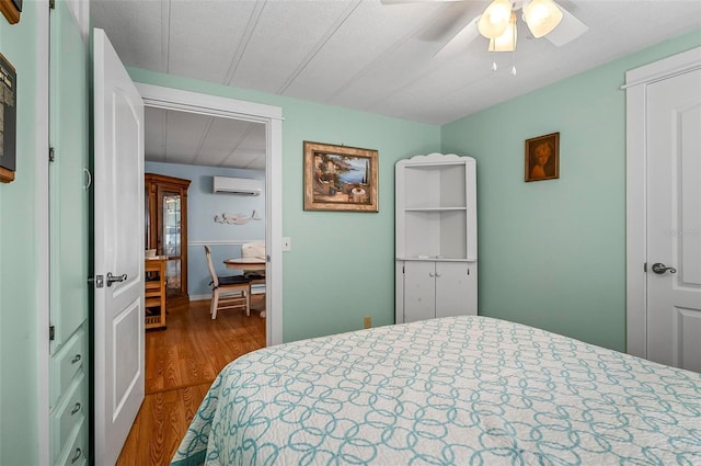 151 Lookout Dr, Flagler Beach, FL 32136 - bedroom with a wall mounted air conditioner, wood finished floors, and a ceiling fan