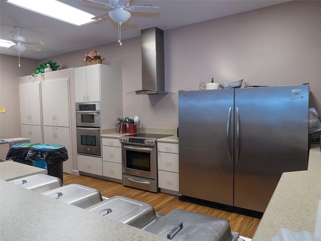 151 Lookout Dr, Flagler Beach, FL 32136 - kitchen featuring appliances with stainless steel finishes, wall chimney exhaust hood, ceiling fan, light countertops, and white cabinetry