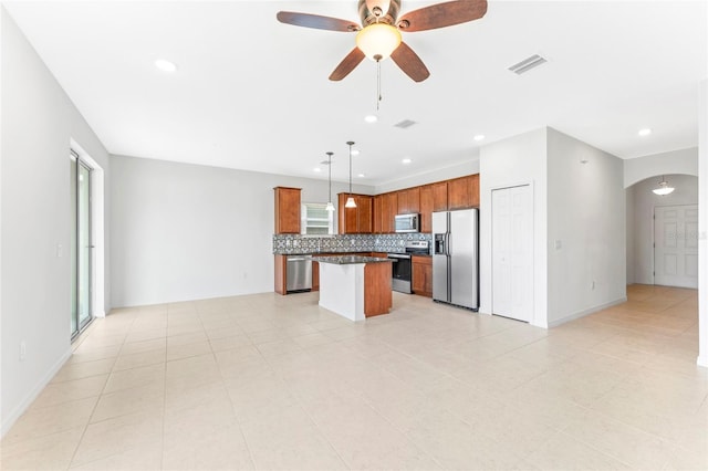 3 Oakleaf Way, Palm Coast, FL 32137 - kitchen with appliances with stainless steel finishes, open floor plan, arched walkways, tasteful backsplash, and a kitchen island