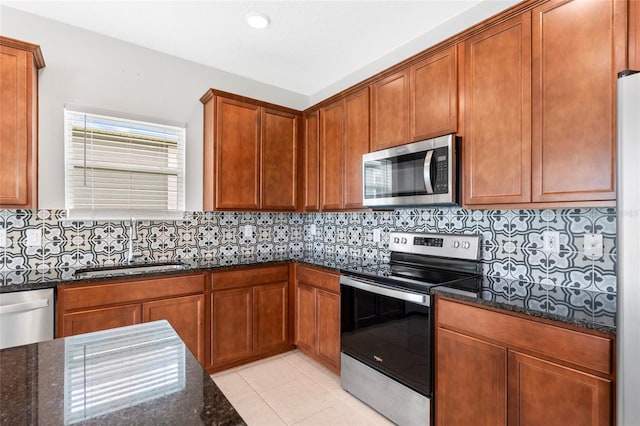 3 Oakleaf Way, Palm Coast, FL 32137 - kitchen featuring stainless steel appliances, a sink, dark stone countertops, backsplash, and light tile patterned floors
