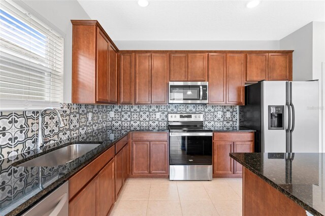 3 Oakleaf Way, Palm Coast, FL 32137 - kitchen featuring appliances with stainless steel finishes, a sink, dark stone counters, brown cabinets, and recessed lighting
