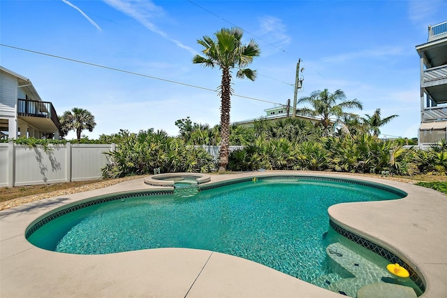 view of swimming pool with fence and a pool with connected hot tub
