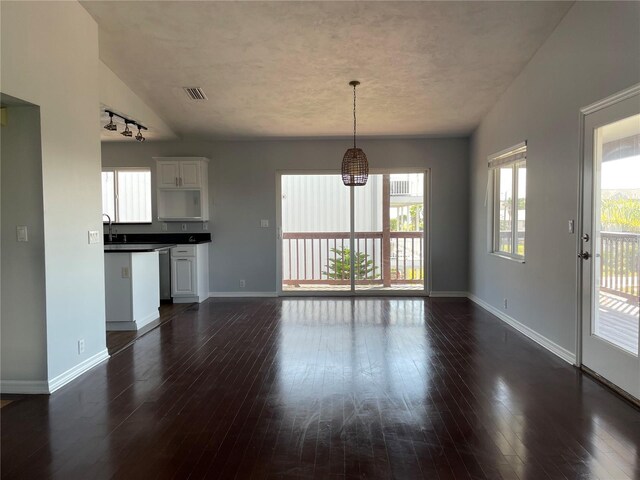 unfurnished living room featuring baseboards and dark wood-style flooring