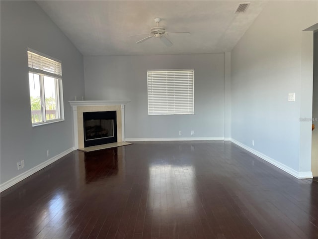 unfurnished living room with ceiling fan, a fireplace, dark wood-type flooring, baseboards, and lofted ceiling