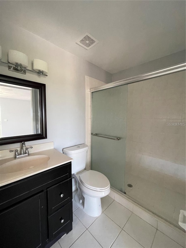bathroom featuring a shower stall, vanity, toilet, and tile patterned floors