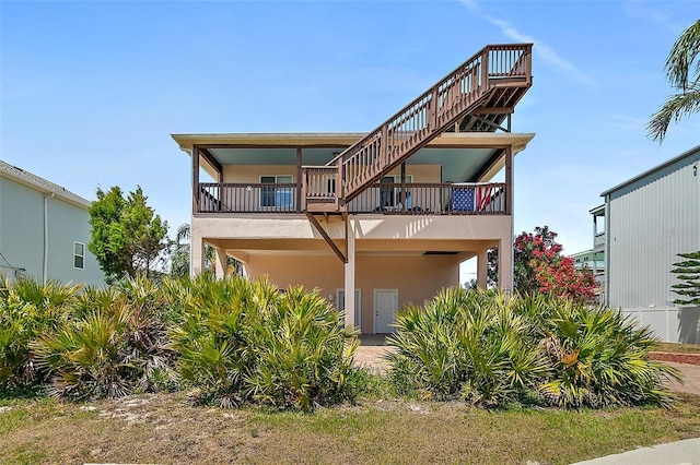 back of property with a balcony and stucco siding