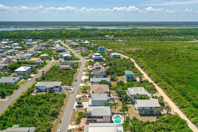 aerial view of residential area featuring a nearby body of water and a pool