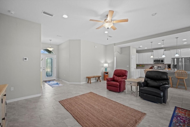 living area with a ceiling fan, recessed lighting, and baseboards