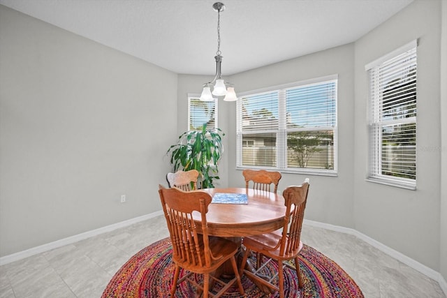dining room featuring baseboards and a chandelier
