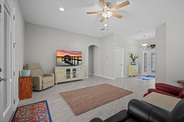living area with arched walkways, a ceiling fan, recessed lighting, and baseboards