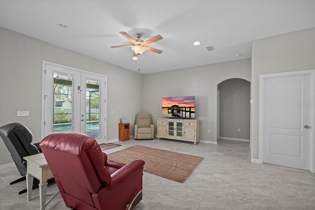 living room with arched walkways, french doors, ceiling fan, baseboards, and recessed lighting