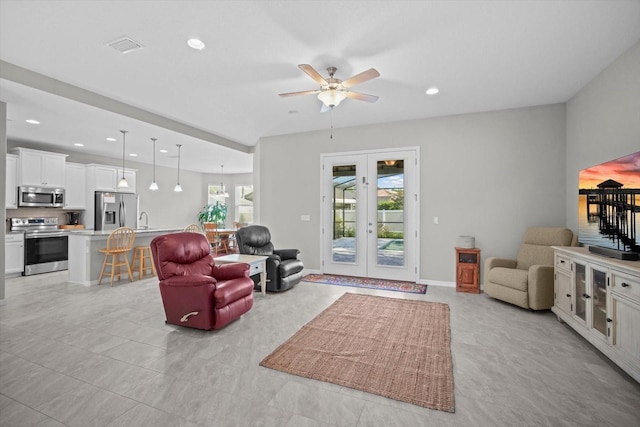 living area with french doors, a ceiling fan, recessed lighting, and light tile patterned flooring