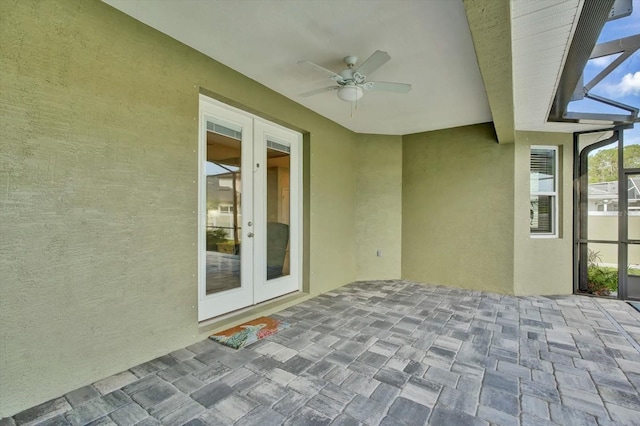 view of patio / terrace with french doors, a ceiling fan, and glass enclosure