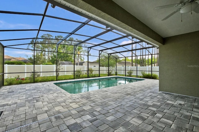 view of swimming pool with ceiling fan, a patio area, a fenced backyard, and a lanai