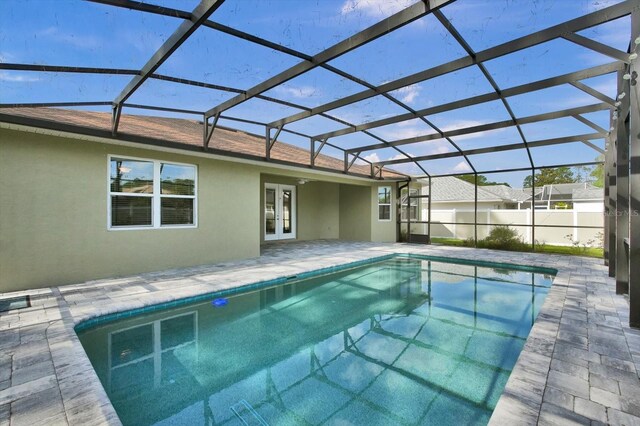 view of pool with french doors, a patio, and glass enclosure
