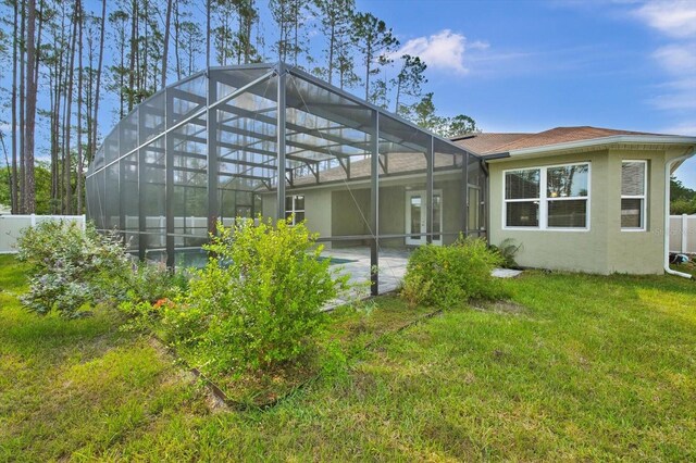 back of property featuring stucco siding, a lanai, and a shingled roof