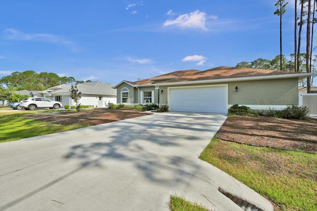 ranch-style house with a garage, driveway, and stucco siding