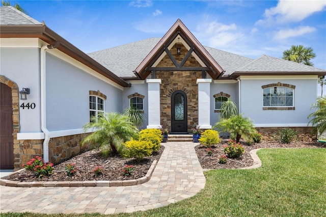 440 Lambert Ave, Flagler Beach, FL 32136 - view of front of home with stone siding, stucco siding, a shingled roof, and a front yard